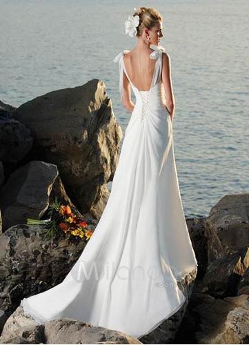bride standing on rocks by the sea